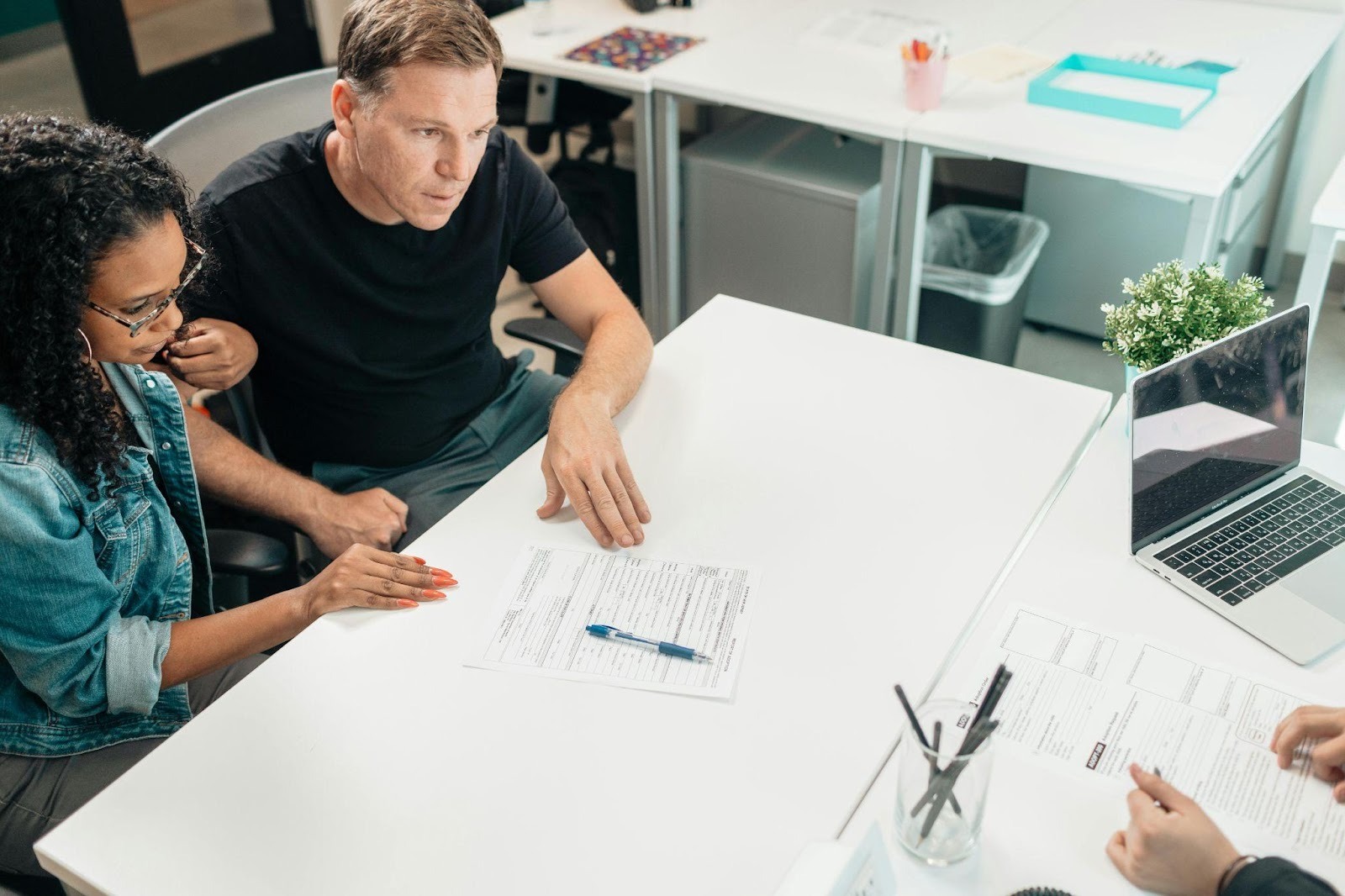 A couple sits across from a mediator in a formal office setting.