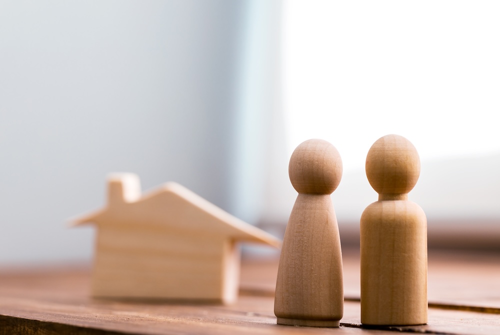 miniature wooden people and house